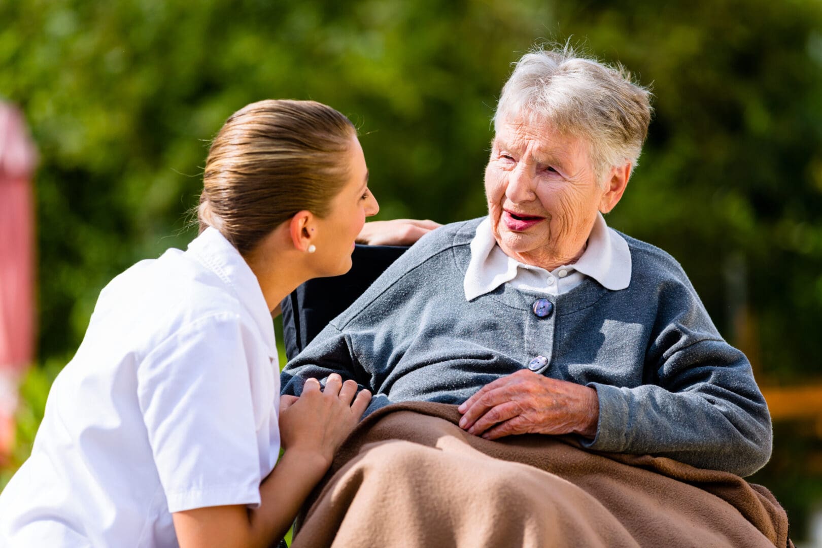 Nurse,Holding,Hands,With,Senior,Woman,Sitting,In,Wheelchair,In