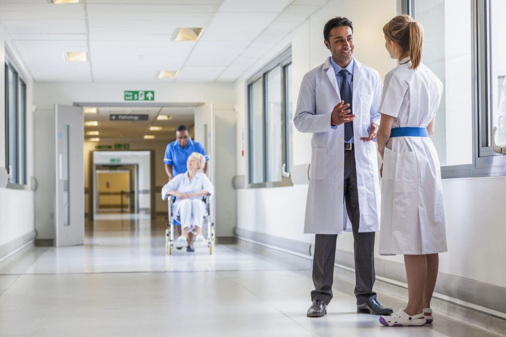 Asian,Indian,Male,Doctor,&amp;,Female,Nurse,In,Hospital,Corridor