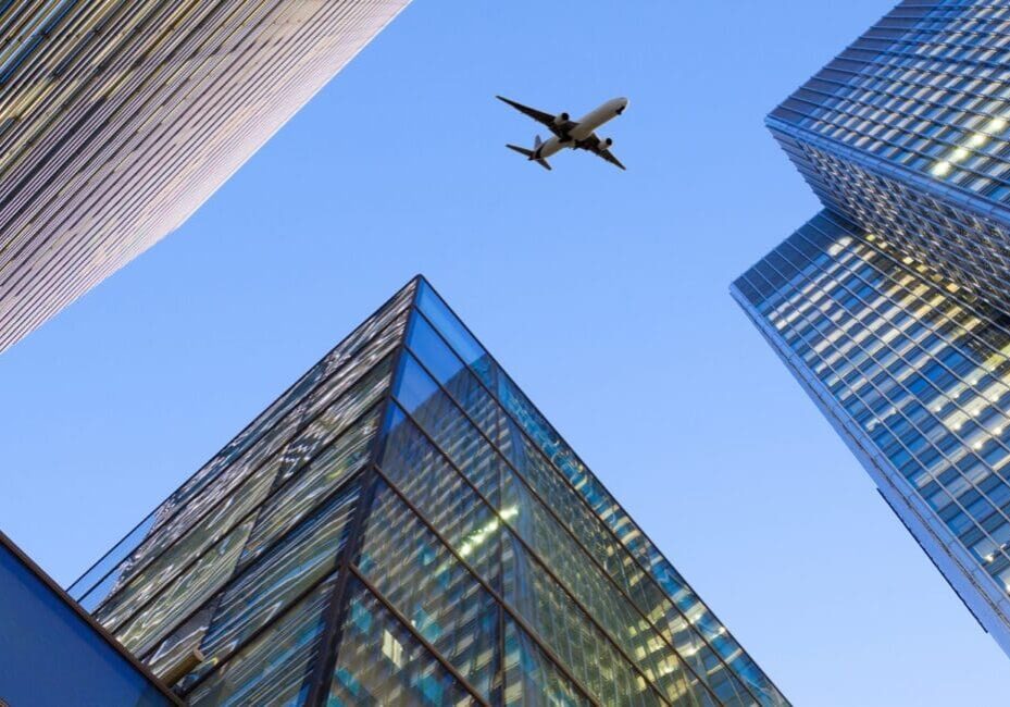 A,Jet,Airplane,Silhouette,With,Business,Office,Towers,Background